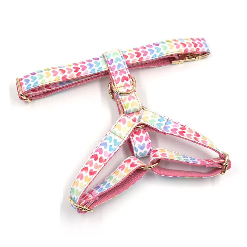Pink dog harness with gold buckle and heart-shaped stone decoration on a chest and back strap
