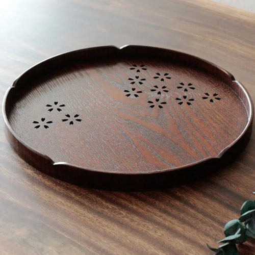 12 wooden circular plates with sakura flower cut-out designs arranged with storage tray