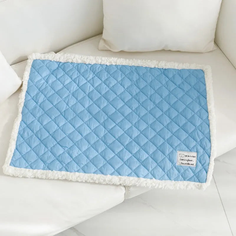 Quilted terry cloth cat blanket in blue, shown alongside pink, yellow, and grey colour options.