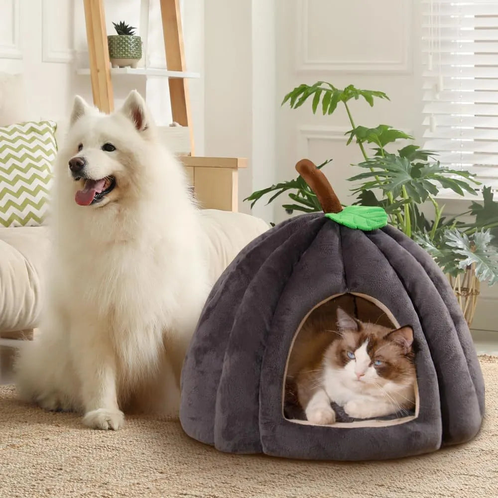 Pumpkin-shaped plush cat cave bed with a round entry hole on a wooden floor.