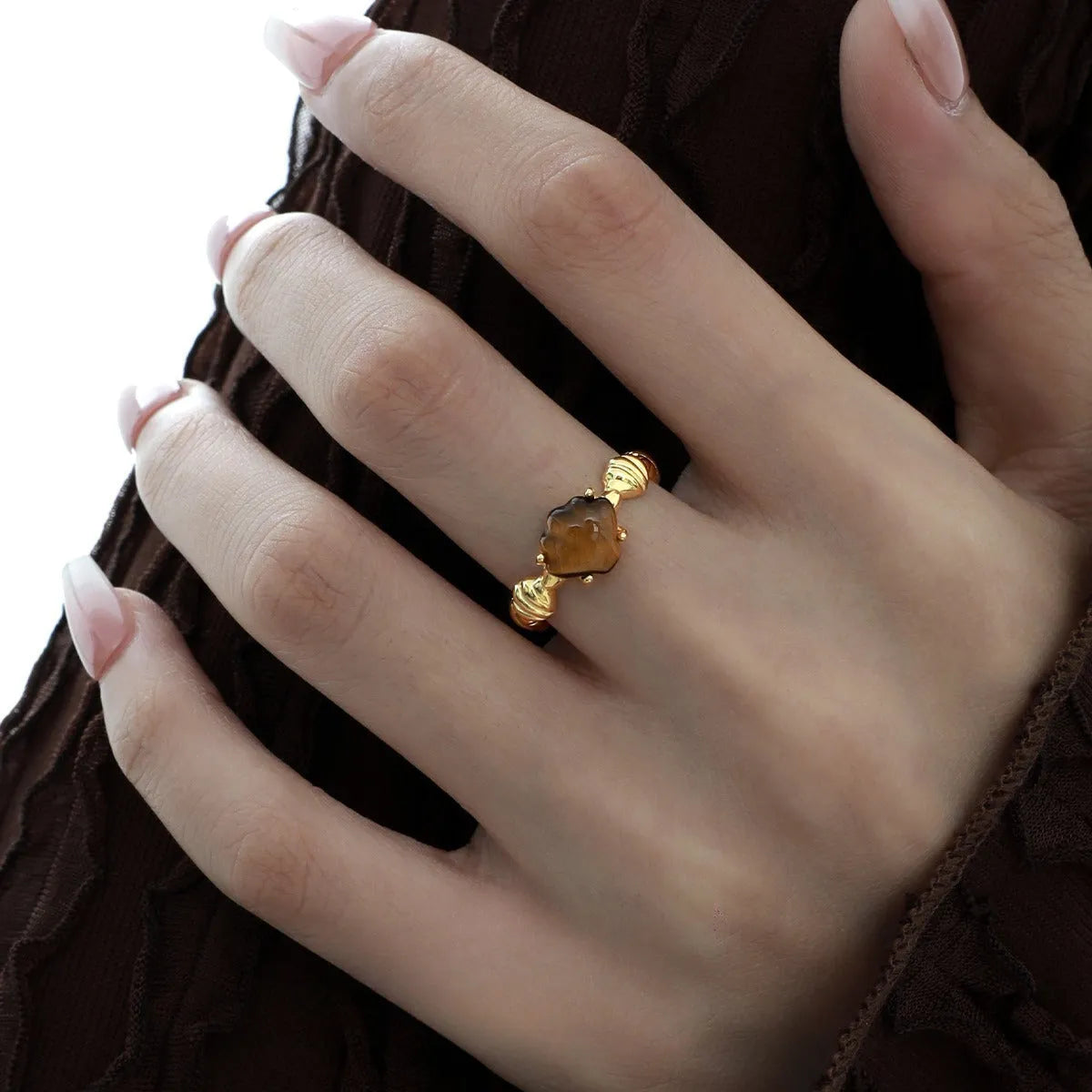 Adjustable silver ring with a shell design and tiger eye stone in white gold or gold finish.