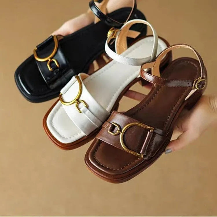 Women's black leather sandals with a thick rubber sole and a round toe, fastened with a button.