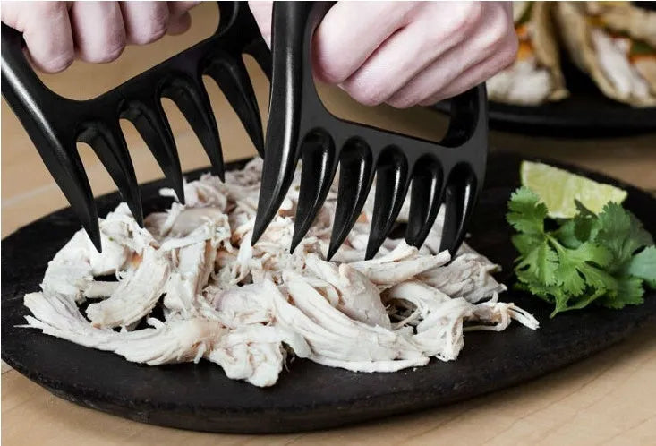 Two black bear claw meat shredder forks with patterned handles for barbecue use.