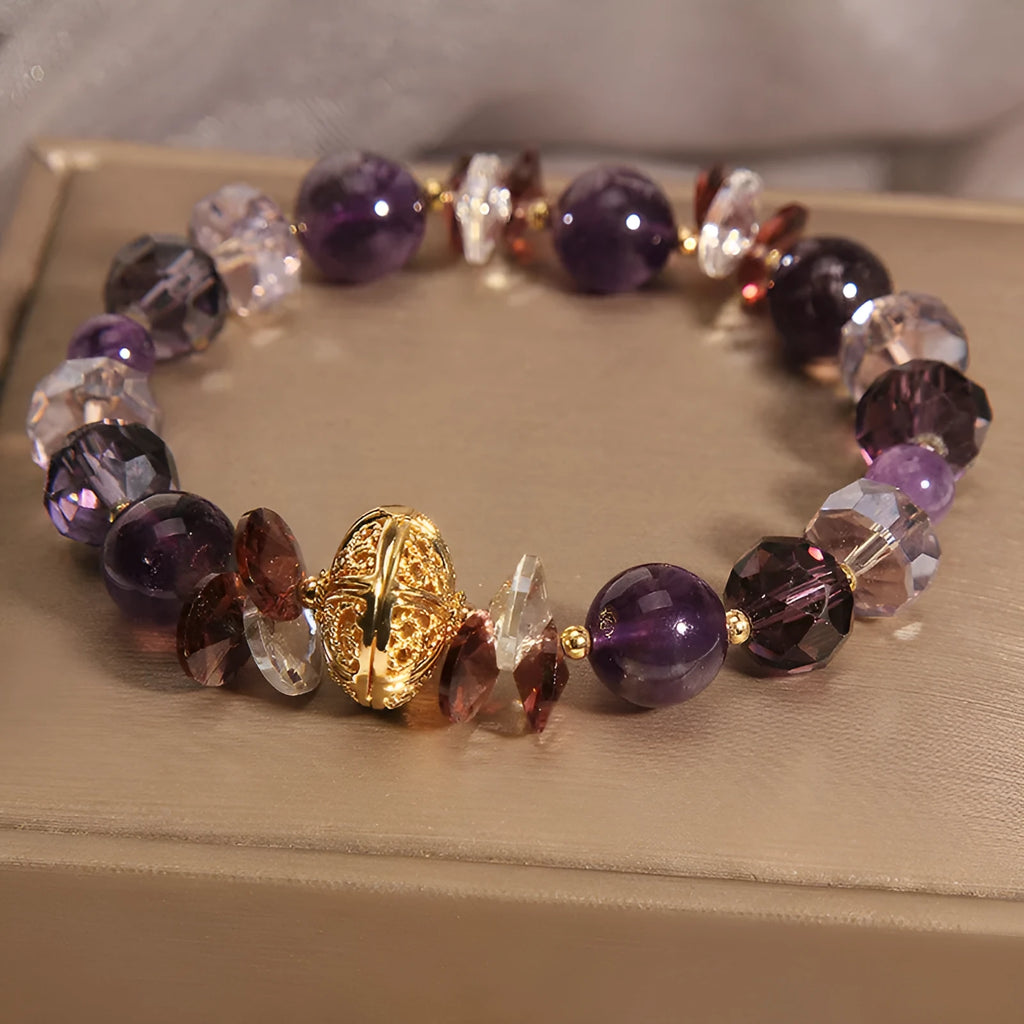 Purple crystal bracelet with pumpkin beads, wind chime charms, and rhinestone details on wrist