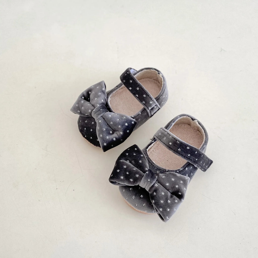 Baby girl toddler shoes with big bow and dots pattern in black on white background