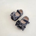 Baby girl toddler shoes with big bow and dots pattern in black on white background