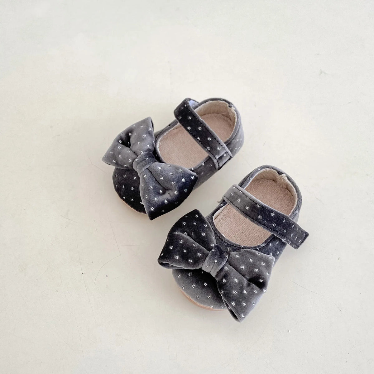 Baby girl toddler shoes with big bow and dots pattern in black on white background