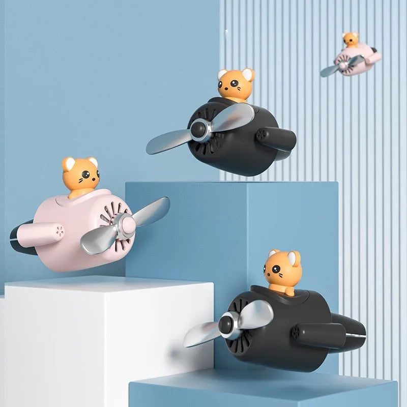 Cartoon aeroplane-shaped plastic clip for car air vent, includes fragrance slices, in black, blue, orange, or pink.