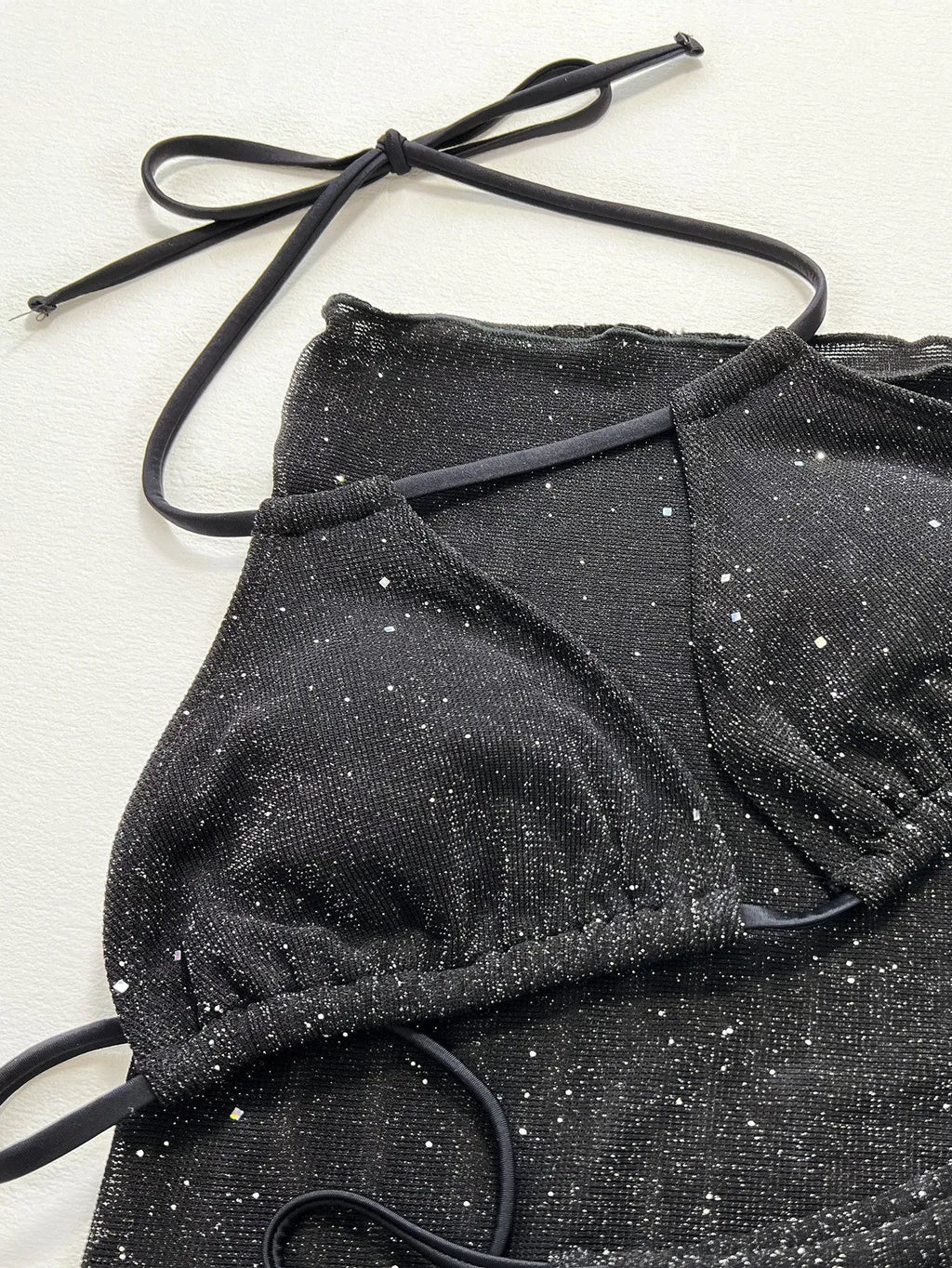 Black three-piece bikini swimsuit set with polyester fabric, showing top and shorts components