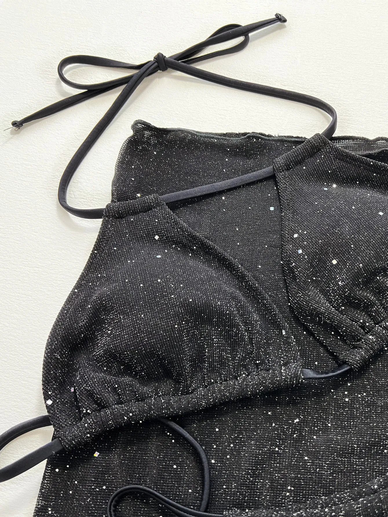 Black three-piece bikini swimsuit set with polyester fabric, showing top and shorts components