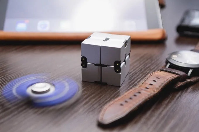 Zinc alloy infinity cube fidget toy in black or silver, showing rotating cubes on a 4cm scale.