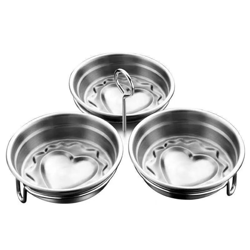Small stainless steel egg steamer in both round and love-shaped designs on a kitchen counter.