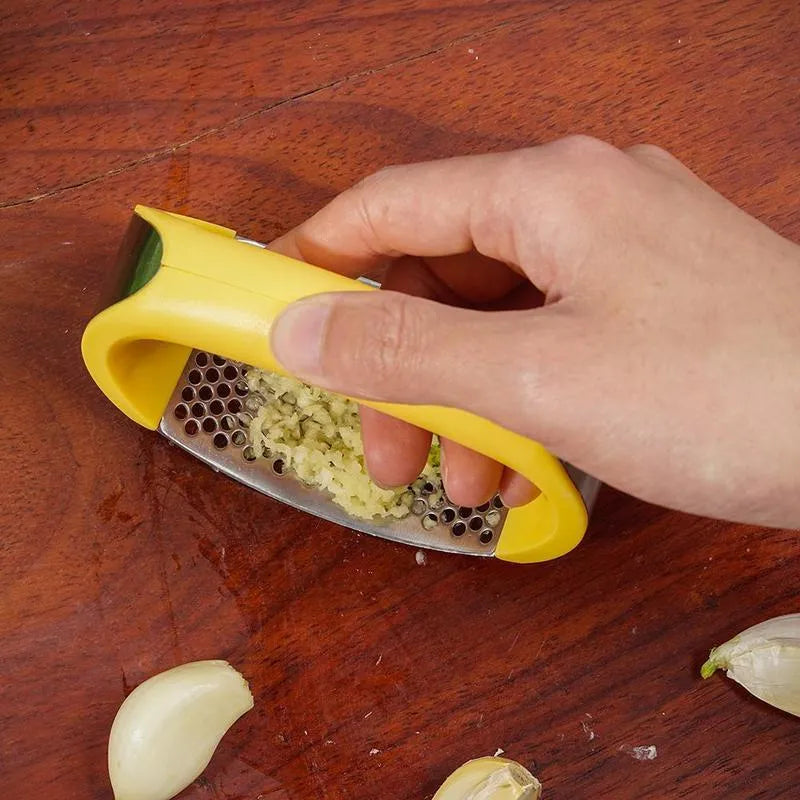 A stainless steel garlic press with a curved design and non-slip ergonomic handle.