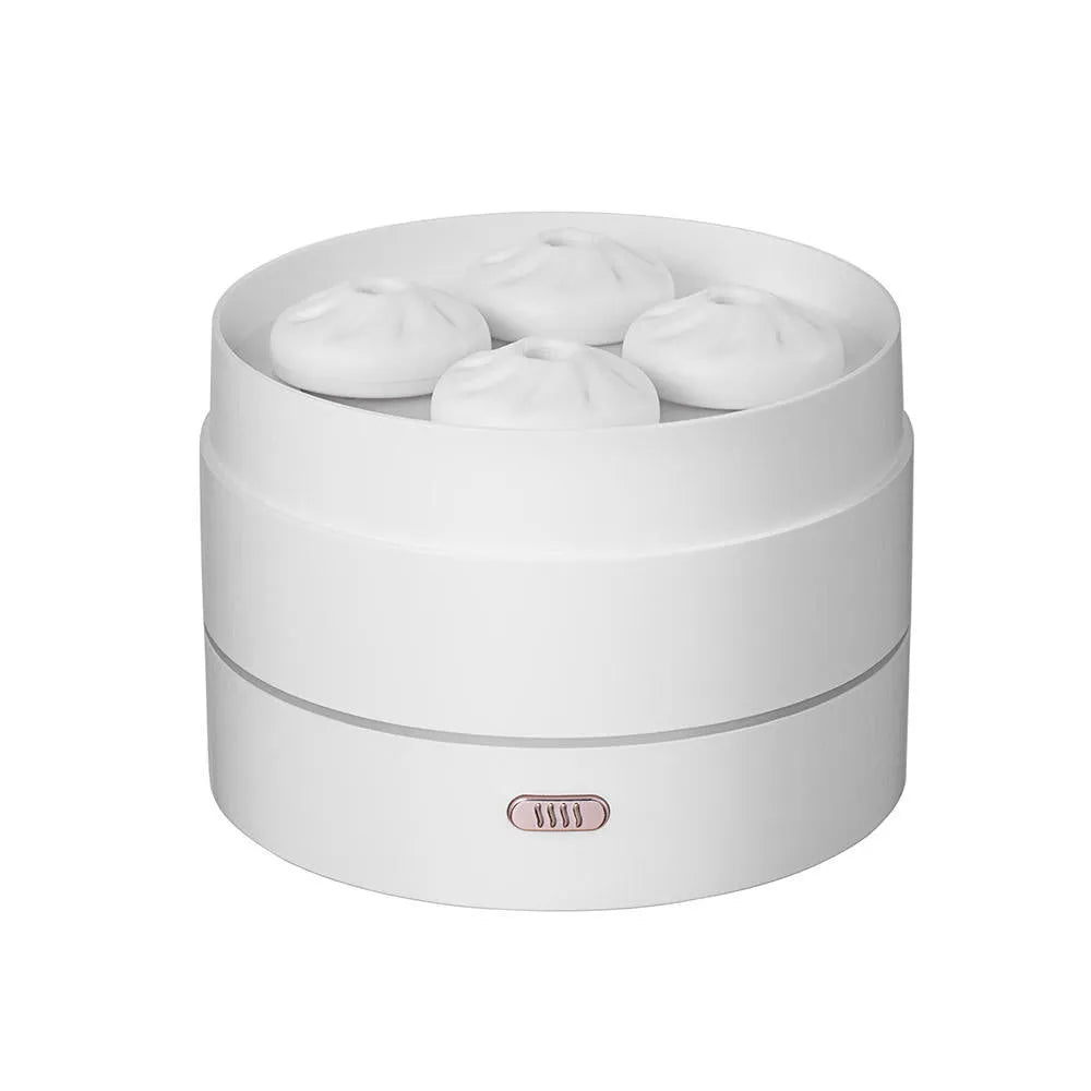 White ultrasonic aroma diffuser with four steam nozzles and LED light on a wooden table