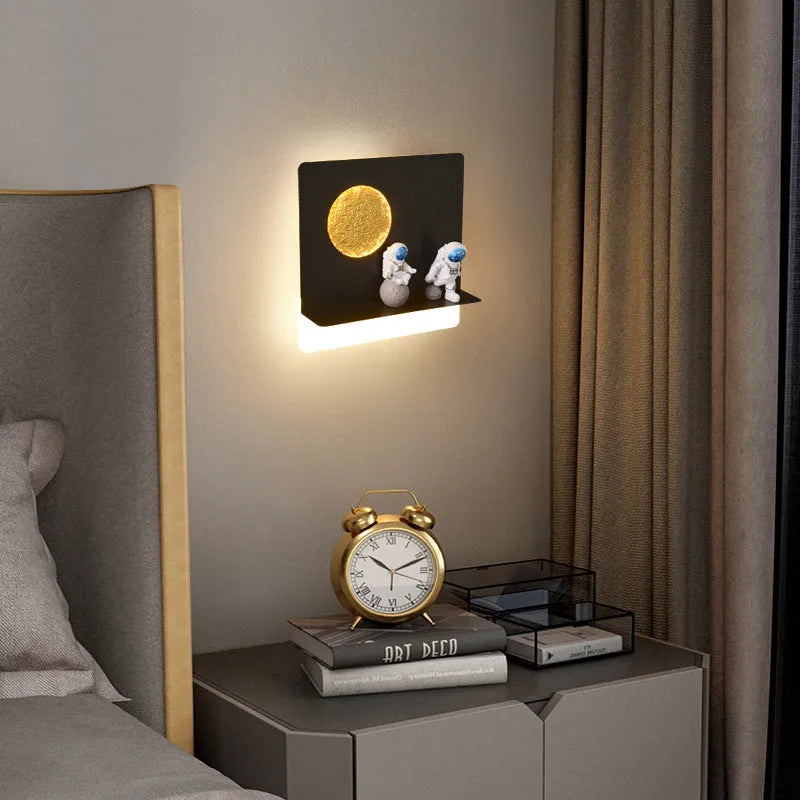 Modern black or white astronaut-shaped wall lamp with integrated shelf and LED light for bedside use.