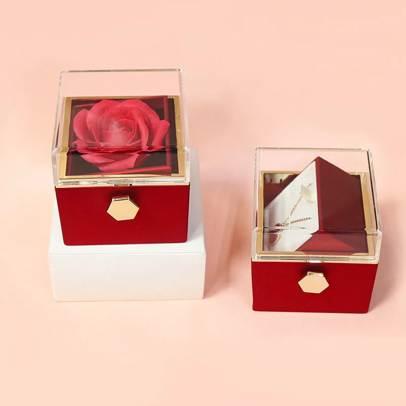Rotating jewellery box with preserved red rose under acrylic cover and drawer open showing storage