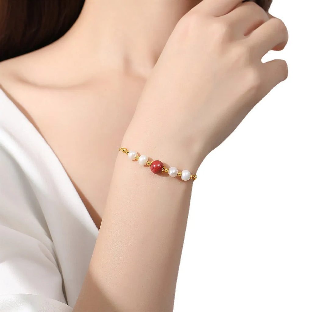 Yellow retro-style bracelet with red cinnabar beads and white pearls on a silver chain.