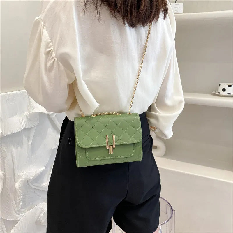 Women's crossbody bag with diamond lattice chain strap in black PU leather showing front view
