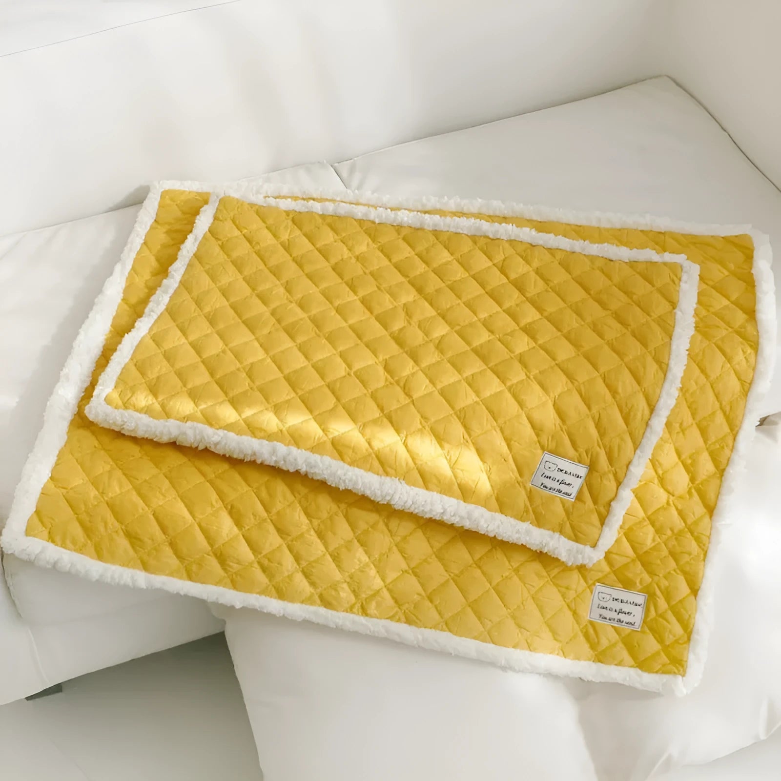 Quilted terry cloth cat blanket in blue, shown alongside pink, yellow, and grey colour options.