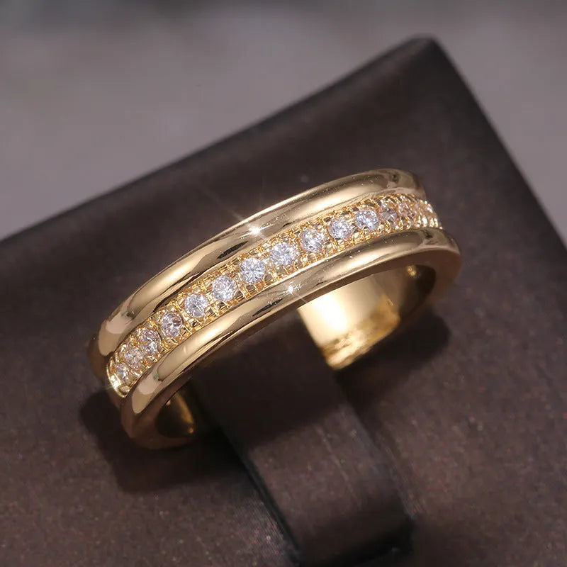 Gold-plated copper geometric ring with inlaid zircon on white background