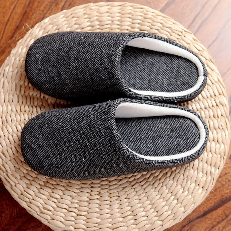 Men's cotton black indoor slippers with anti-skid sole on a home floor