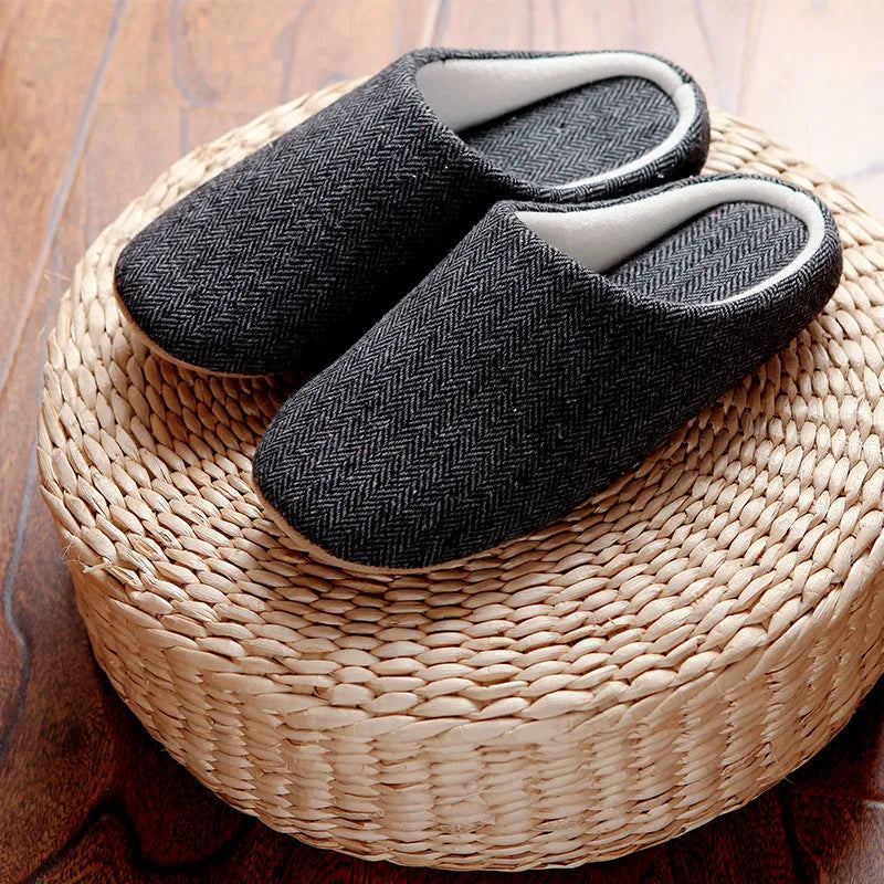 Men's cotton black indoor slippers with anti-skid sole on a home floor