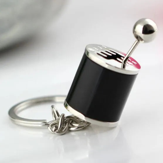 Metal gear shift keychain in polished silver with movable 6-speed and reverse lever