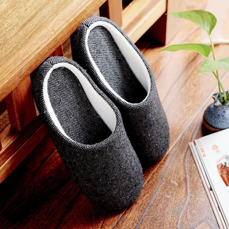 Men's cotton black indoor slippers with anti-skid sole on a home floor