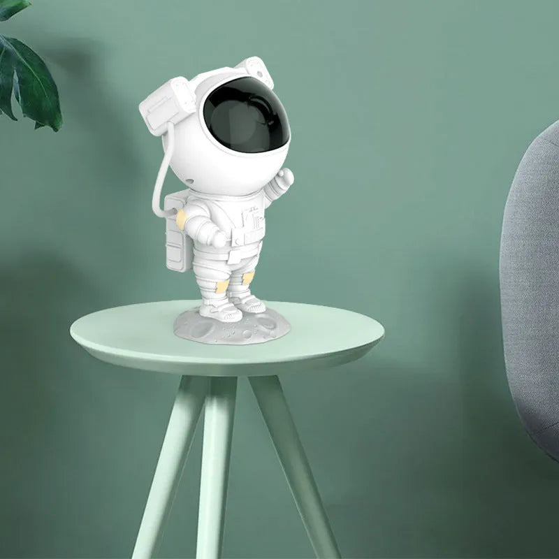 Creative astronaut galaxy starry sky projector nightlight on a table with nebula and star effects displayed against a dark background
