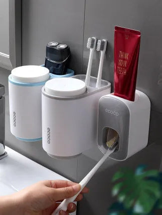Black wall-mounted automatic toothpaste holder with toothbrush storage and suction cup mounting