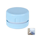 Blue rechargeable mini handheld desktop vacuum cleaner on a wooden desk next to pencils