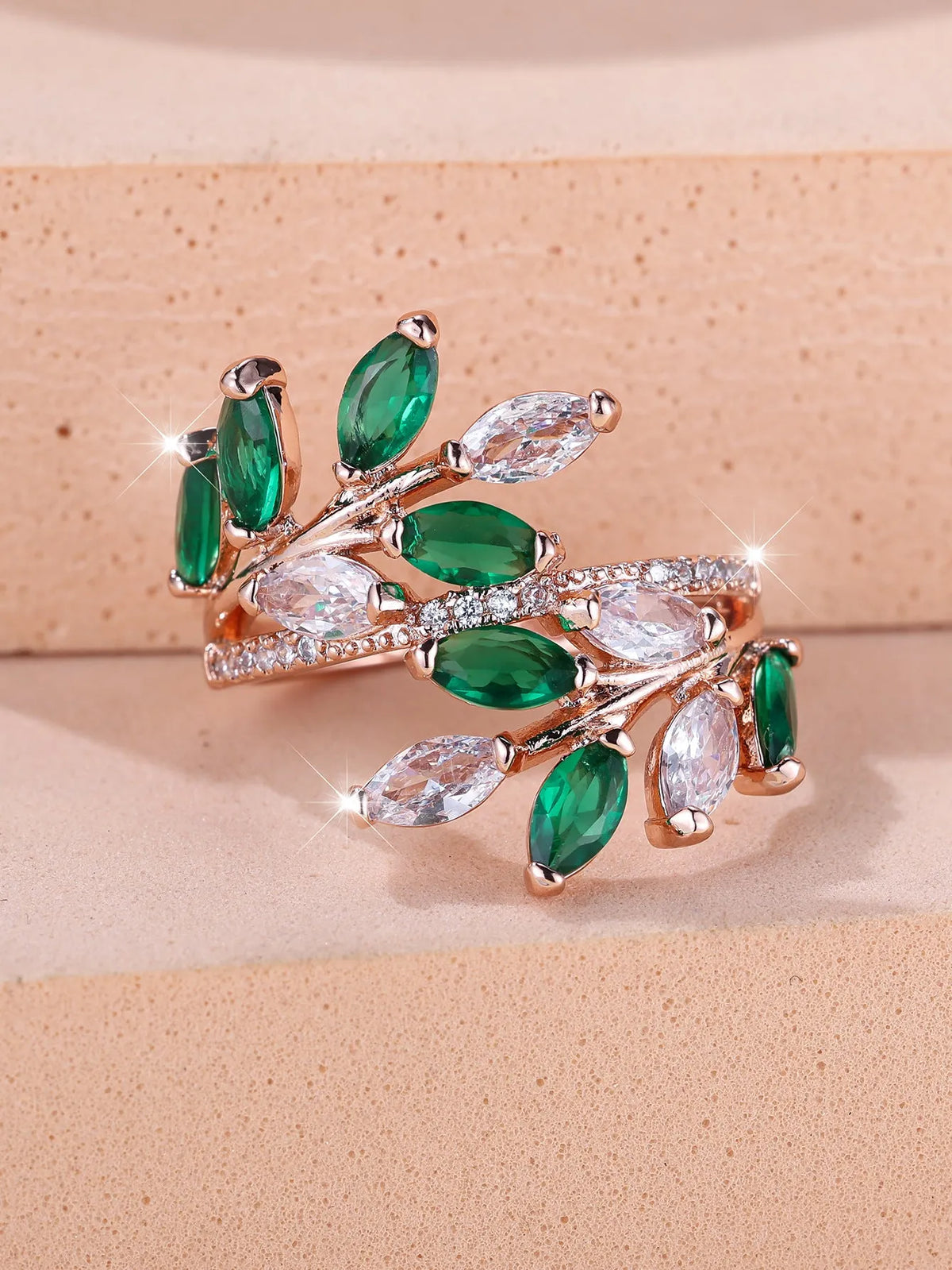 Adjustable copper leaf ring with a horse eye zircon stone in multiple colour finishes on a neutral background.