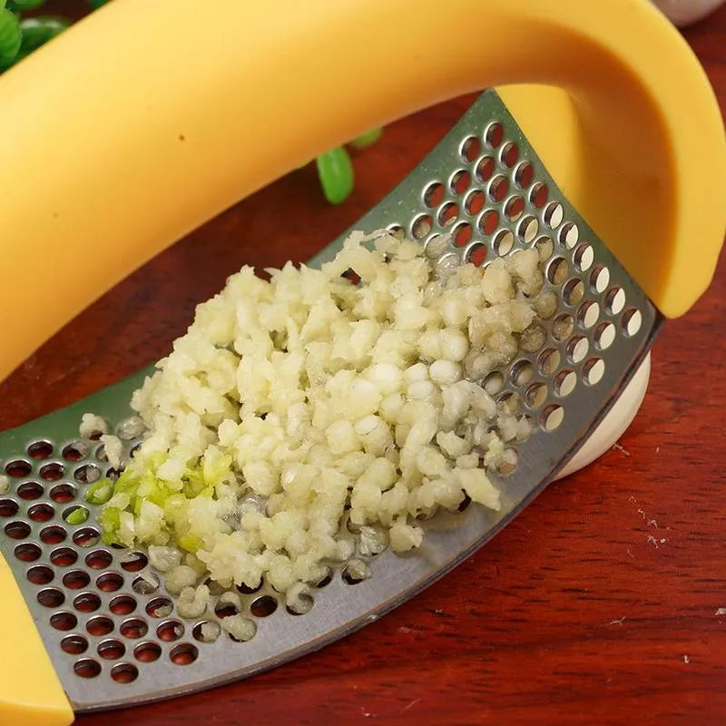 A stainless steel garlic press with a curved design and non-slip ergonomic handle.