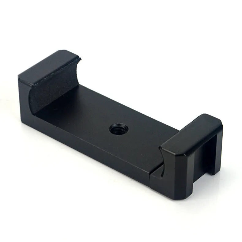 Silver aluminium smartphone bracket for tripod mounting next to a mobile phone.