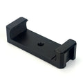 Silver aluminium smartphone bracket for tripod mounting next to a mobile phone.