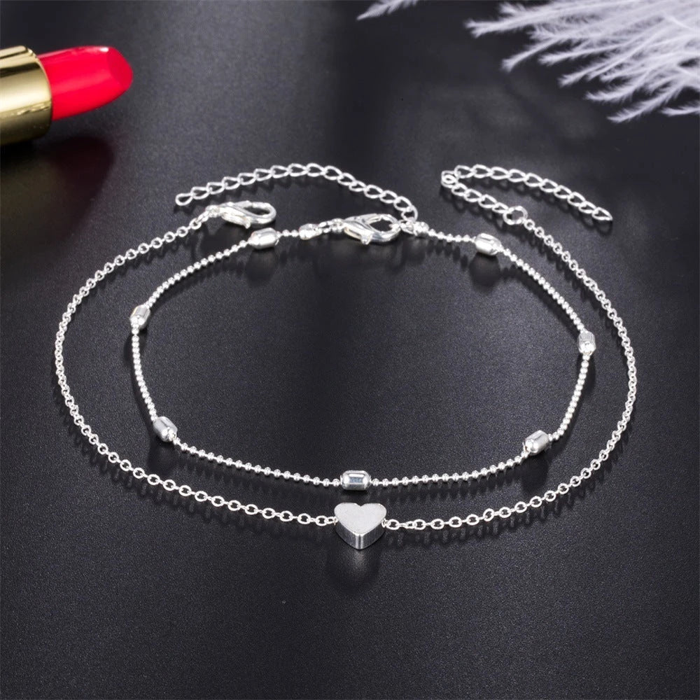 Double-layered heart-shaped anklet with retro beach-inspired chain in gold and silver colors