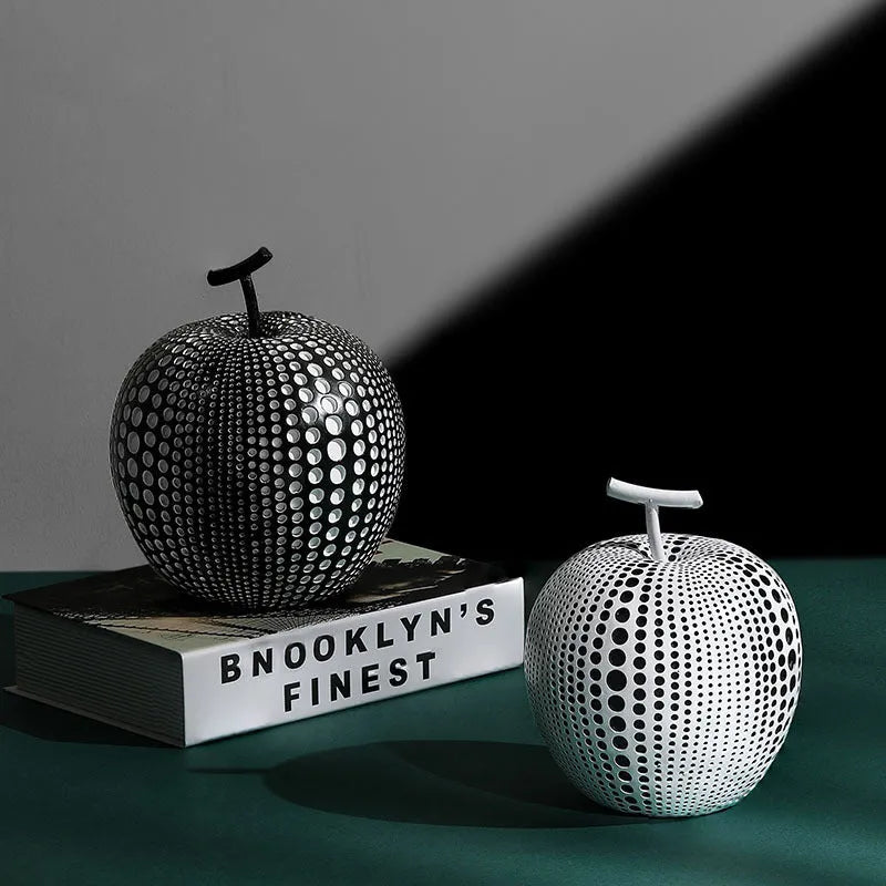 White and black resin apple and pear decorations showing high and low profile models on a wooden surface