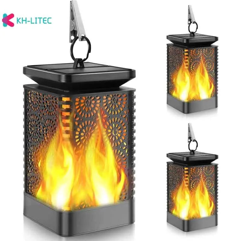 Four black solar-powered hanging torch lights with flame-effect LEDs for outdoor garden decoration.
