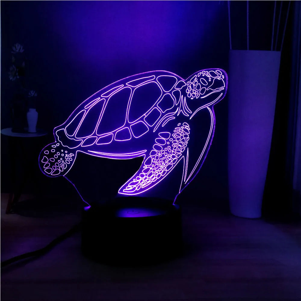 3D clear acrylic turtle-shaped LED night light with remote control on a desk.