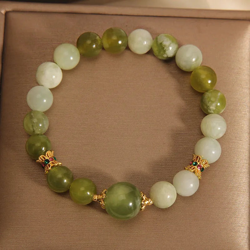 Women's bracelet made of green Xiuyan jade with an original design on a wrist.