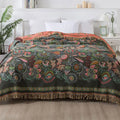 Cotton gauze towel quilt with tassels in beige flower pattern on a bed