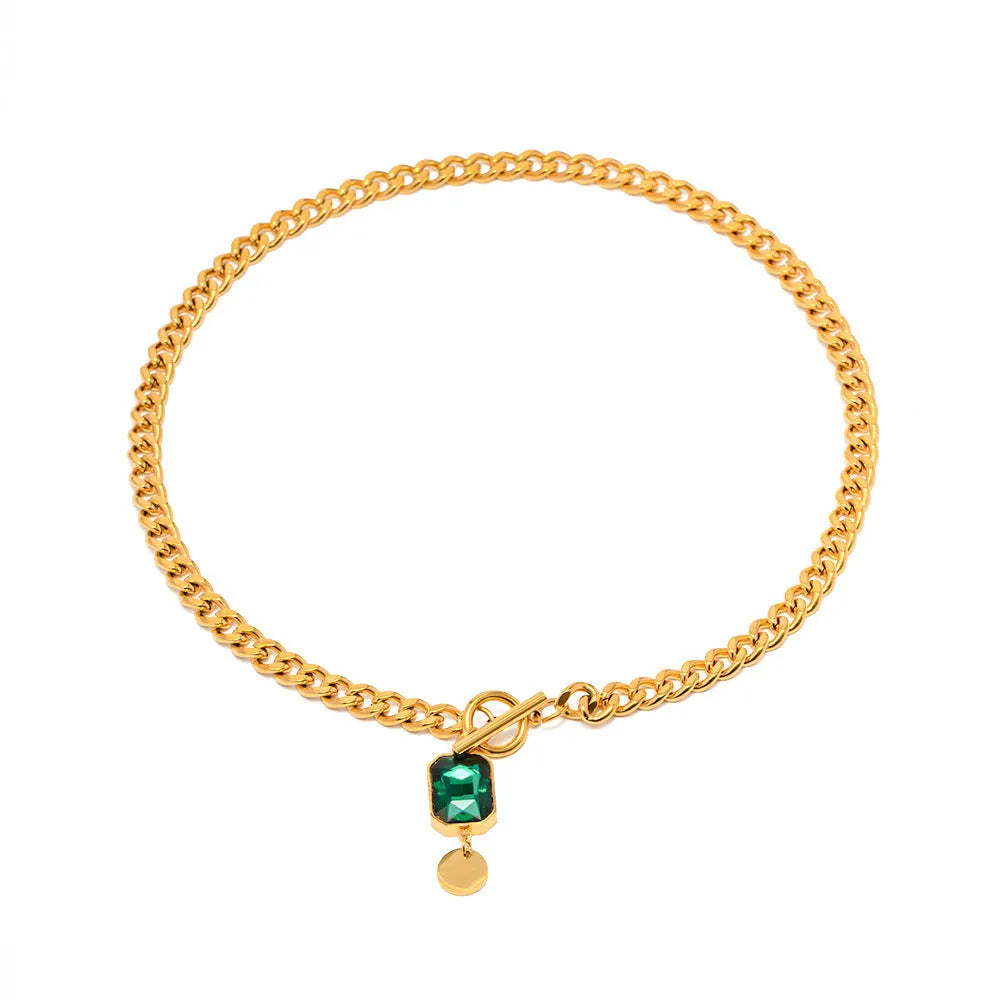 Gold electroplated geometric round pendant necklace with emerald zircon accents on Cuban link chain