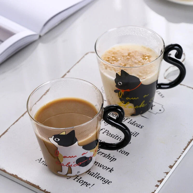 Adorable cat-shaped glass mug with a playful cat tail handle, perfect for coffee, tea, and juice lovers