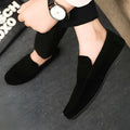 Men's black Gommino style slip-on loafers with round toe and textured rubber sole.
