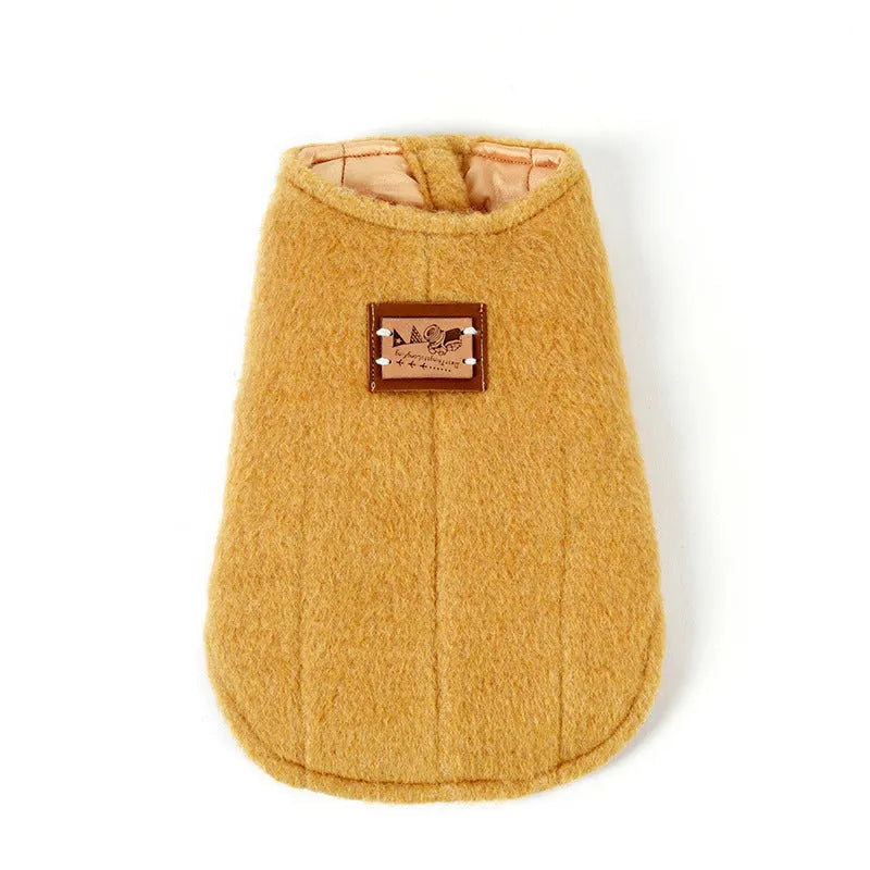 A small dog wearing a blue cotton Korean cashmere vest, a type of casual autumn and winter pet clothing.
