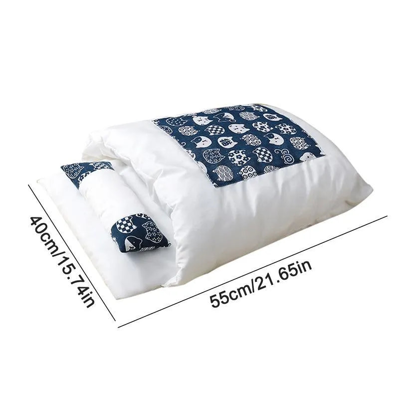 Grey covered cat sleeping bag bed with pillow, shown in medium size on a wooden floor.