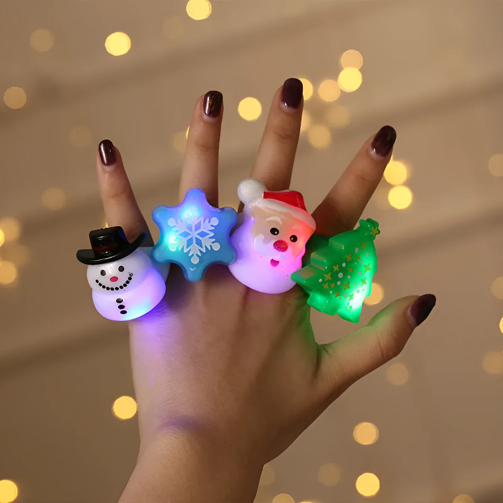 Set of four Christmas party finger lights with designs of small tree, elderly figure, snowflake, and snowman on display