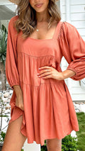 Orange backless A-line dress for a girl with a square collar and puff sleeves.
