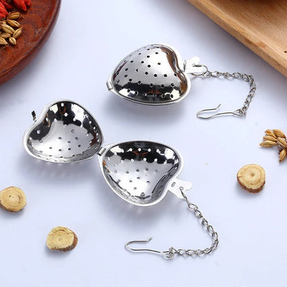 Heart-shaped stainless steel tea infuser with chain, perfect for steeping loose-leaf teas and spices