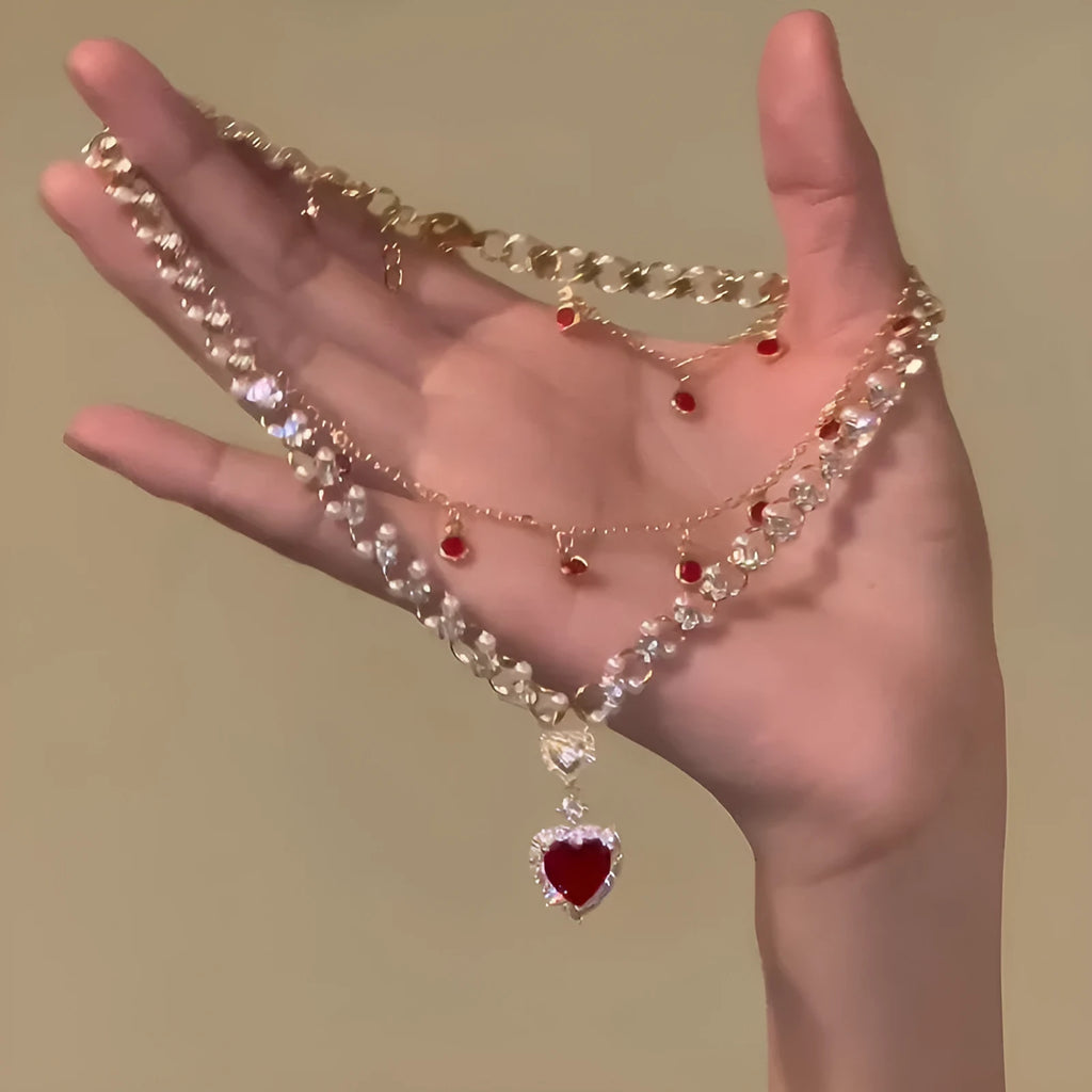Red double layer necklace with twin chains, a pearl pendant, and a love heart pendant on an adjustable alloy chain.